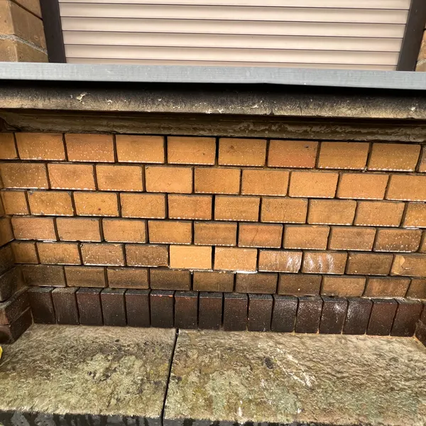 Klinkerfassade unter einem Fenster vor der Reinigung