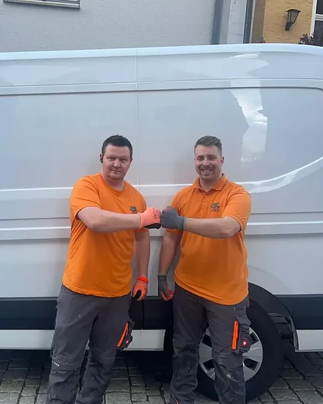 Björn van Diemen und Christian Schlick vor dem Firmenfahrzeug